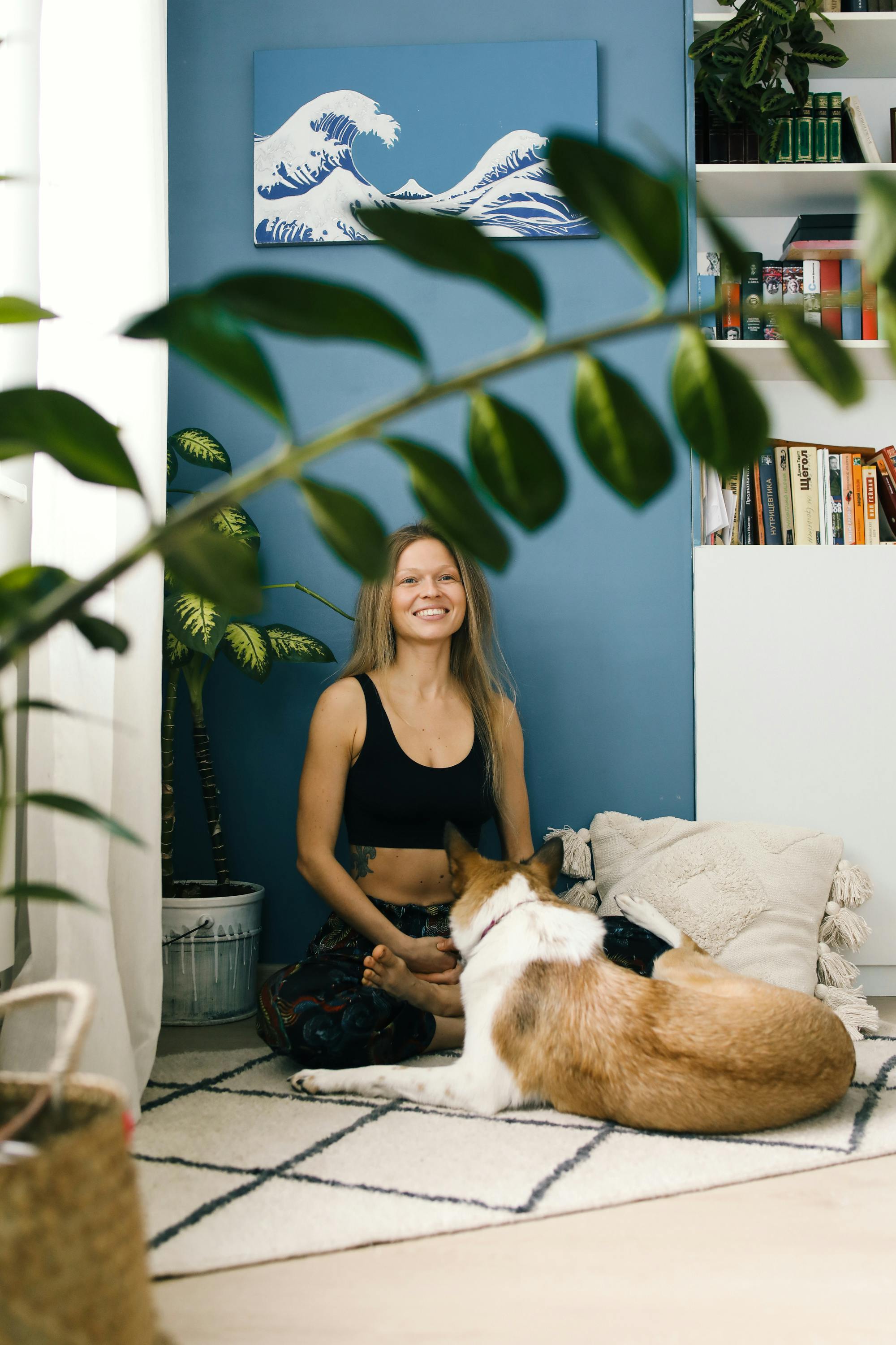 一位放松的女人和一只狗坐在一个舒适、植物丛生的房间里