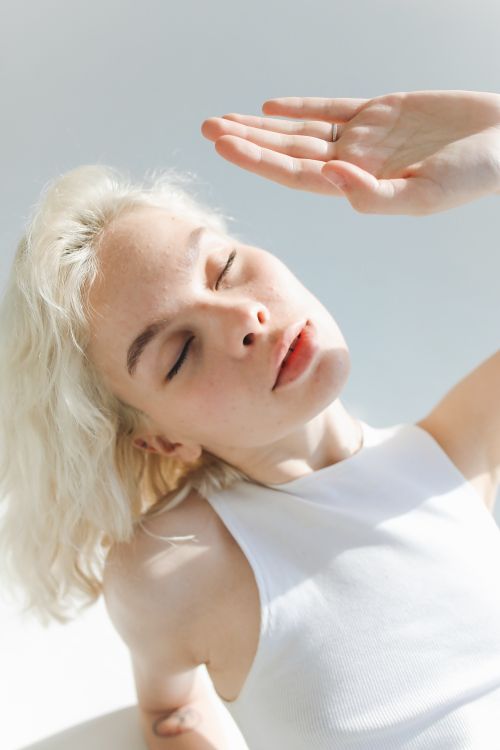 Free Close-up of a woman with closed eyes, basking in soft natural light. Stock Photo
