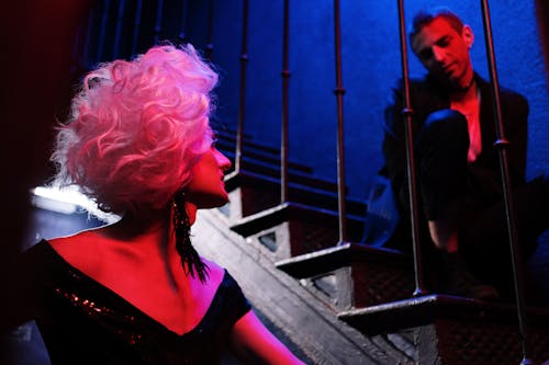 Drag Queen Talking to a Man Sitting on Stairs