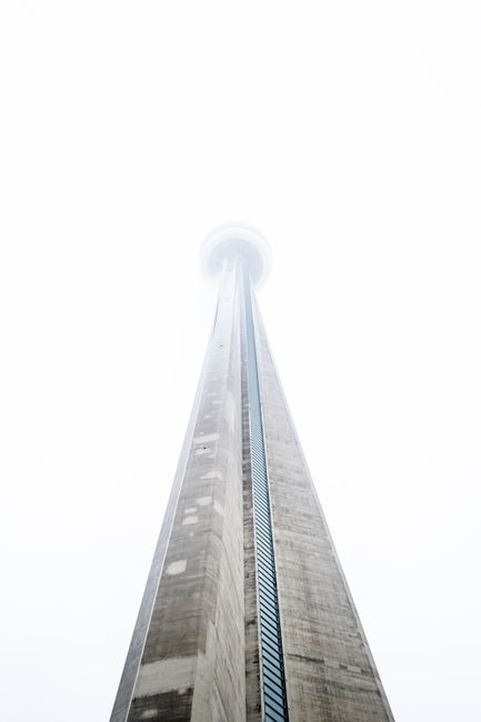 Low angle view of the iconic CN Tower shrouded in mist, Toronto landmark.