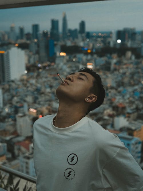 Man in White Crew Neck Shirt Smoking Cigarette