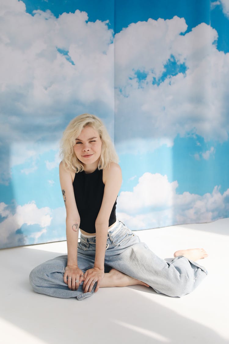 Girl In Black Tank Top And Blue Denim Jeans Winking