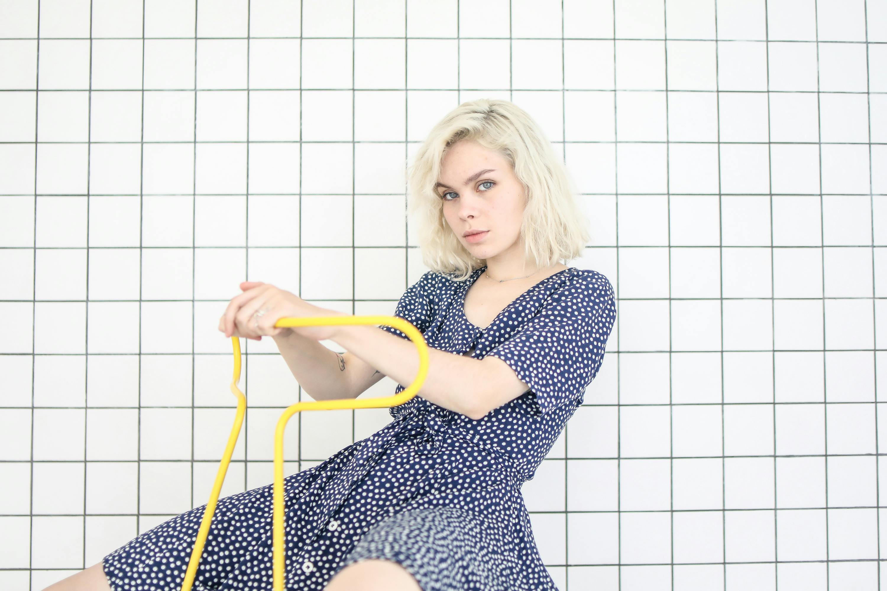 photo of girl in blue dress while sitting on chair