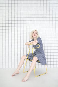 一位金色短发的少女若有所思地坐在黄色椅子上