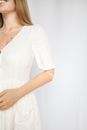 一位身着白色连衣裙的优雅女子展示着她的假肢，流露出自信