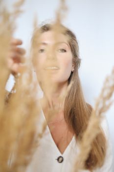 一名女子优雅地在干草后摆出姿势，采用柔焦拍摄，营造出梦幻般的效果