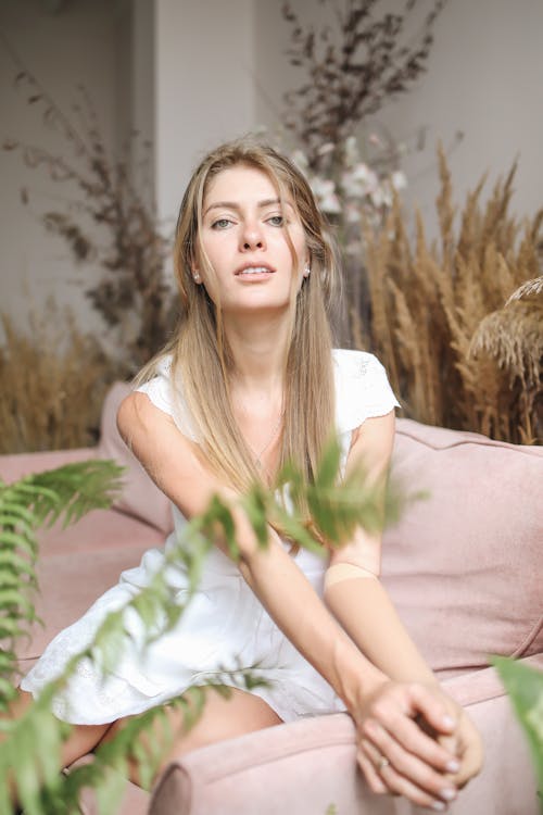 Attractive Woman Sitting on Pink Sofa
