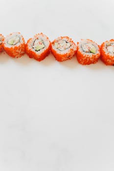 Delicious California sushi rolls with colorful toppings on a light background, ideal for Asian cuisine themes.