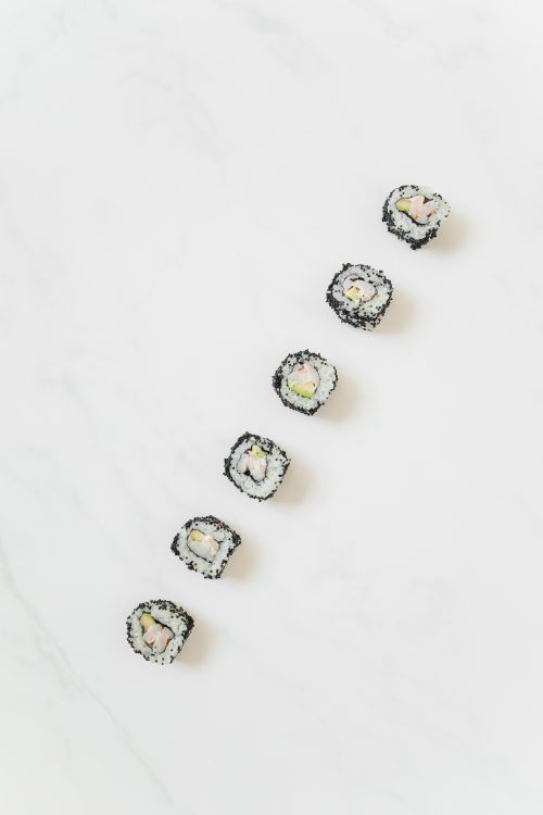 Free Delicate sushi rolls arranged neatly on a light marble surface, capturing an elegant top-down view. Stock Photo