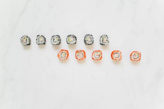 A top view of colorful maki sushi rolls arranged on a white background, perfect for Japanese cuisine themes.