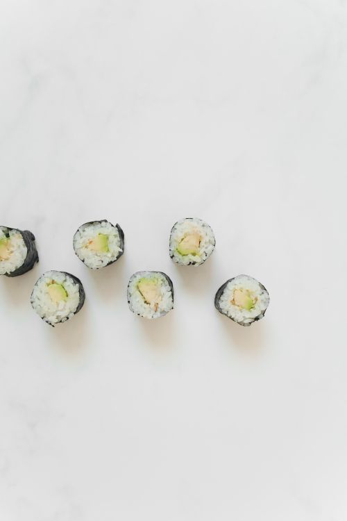Free Top view of Japanese sushi rolls neatly arranged on a white marble surface. Stock Photo