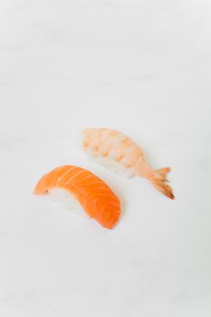 白色背景上，鲑鱼和虾寿司的艺术静物，是理想的食物摄影题材