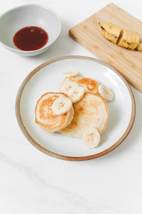 Free Photo of Pancakes With Sliced Banana on White Ceramic Plate Stock Photo