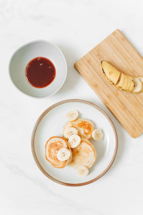 Photo of Pancakes With Banana on White Ceramic Plate