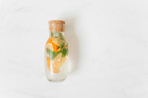 Free Elegant glass jar filled with citrus fruits and mint, perfect for a refreshing drink. Stock Photo