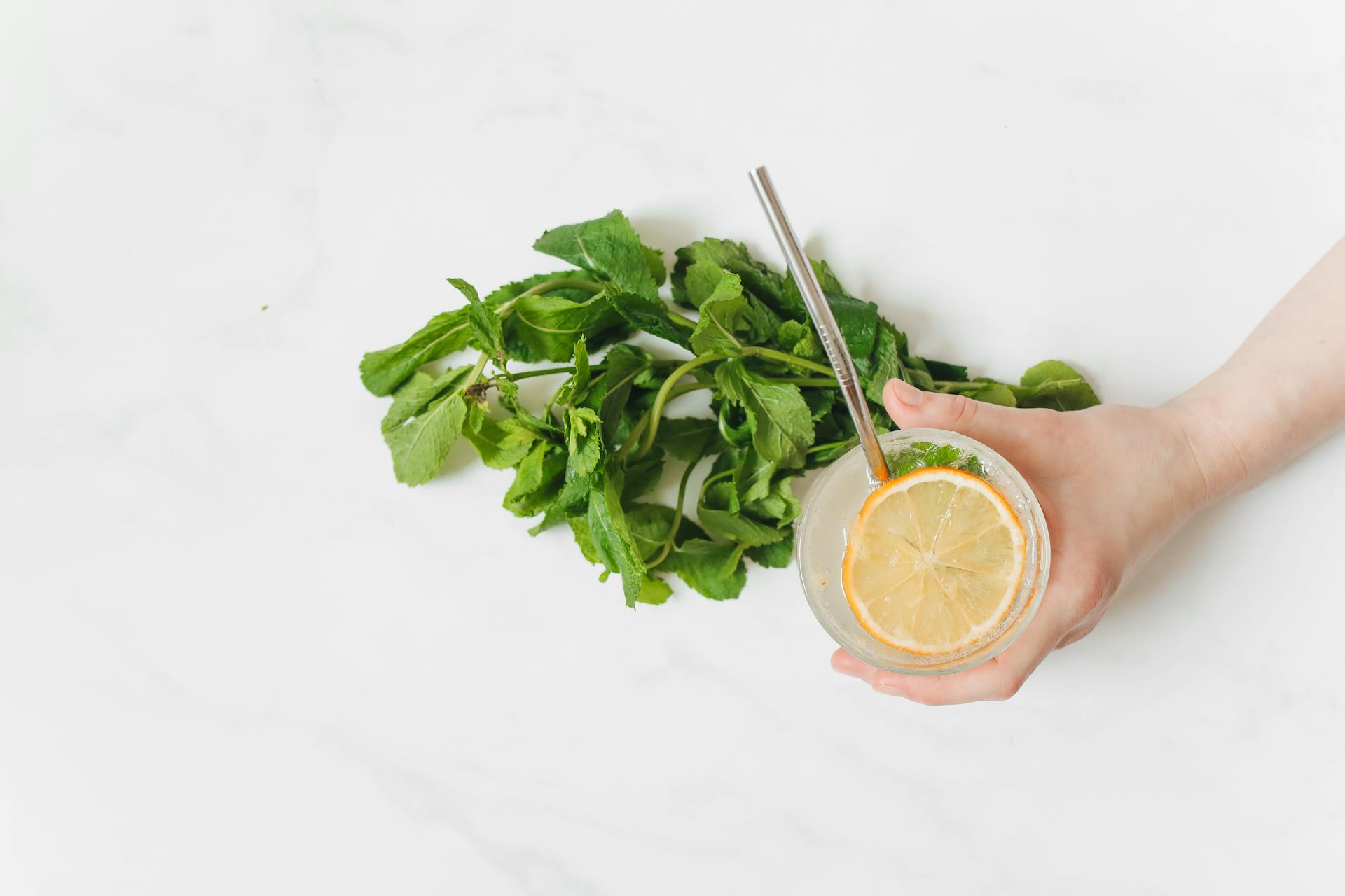 Top view of a fresh lemonade with mint on a white background, perfect for summer themes.