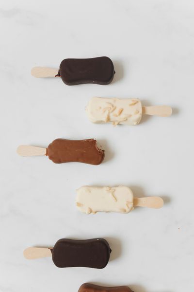 An assortment of chocolate and vanilla ice cream bars on sticks