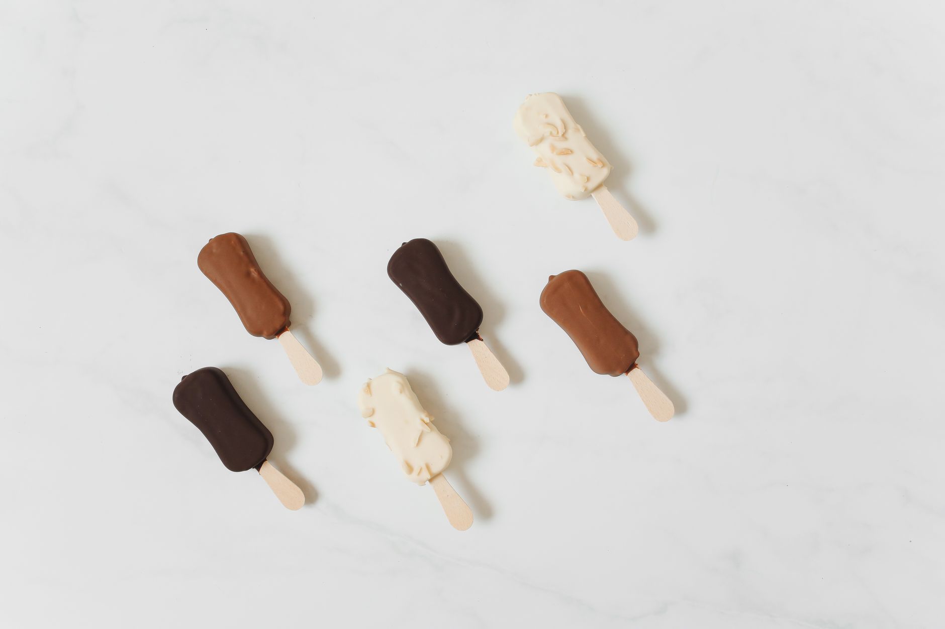 Assorted chocolate ice cream bars on a white surface