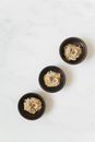 Three Black Round Bowls on White Surface