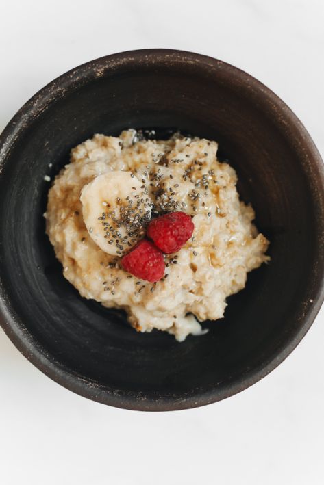 Oatmeal bowl topped with banana, raspberries, and chia seeds