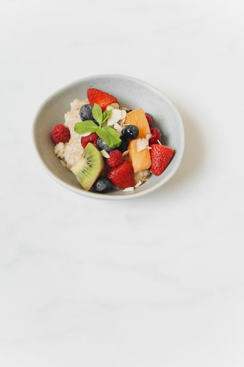 Free Bowl of Oatmeal with Sliced Fruits and Berries Stock Photo