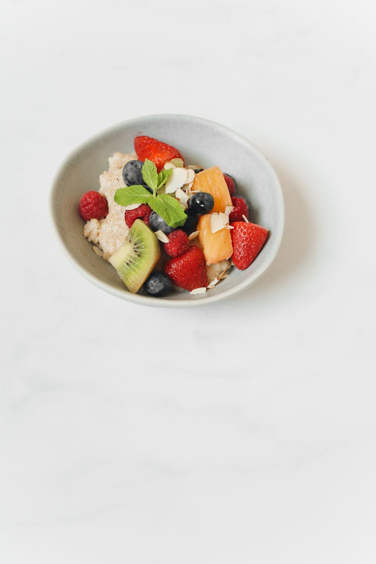 Bowl Of Oatmeal With Sliced Fruits And Berries