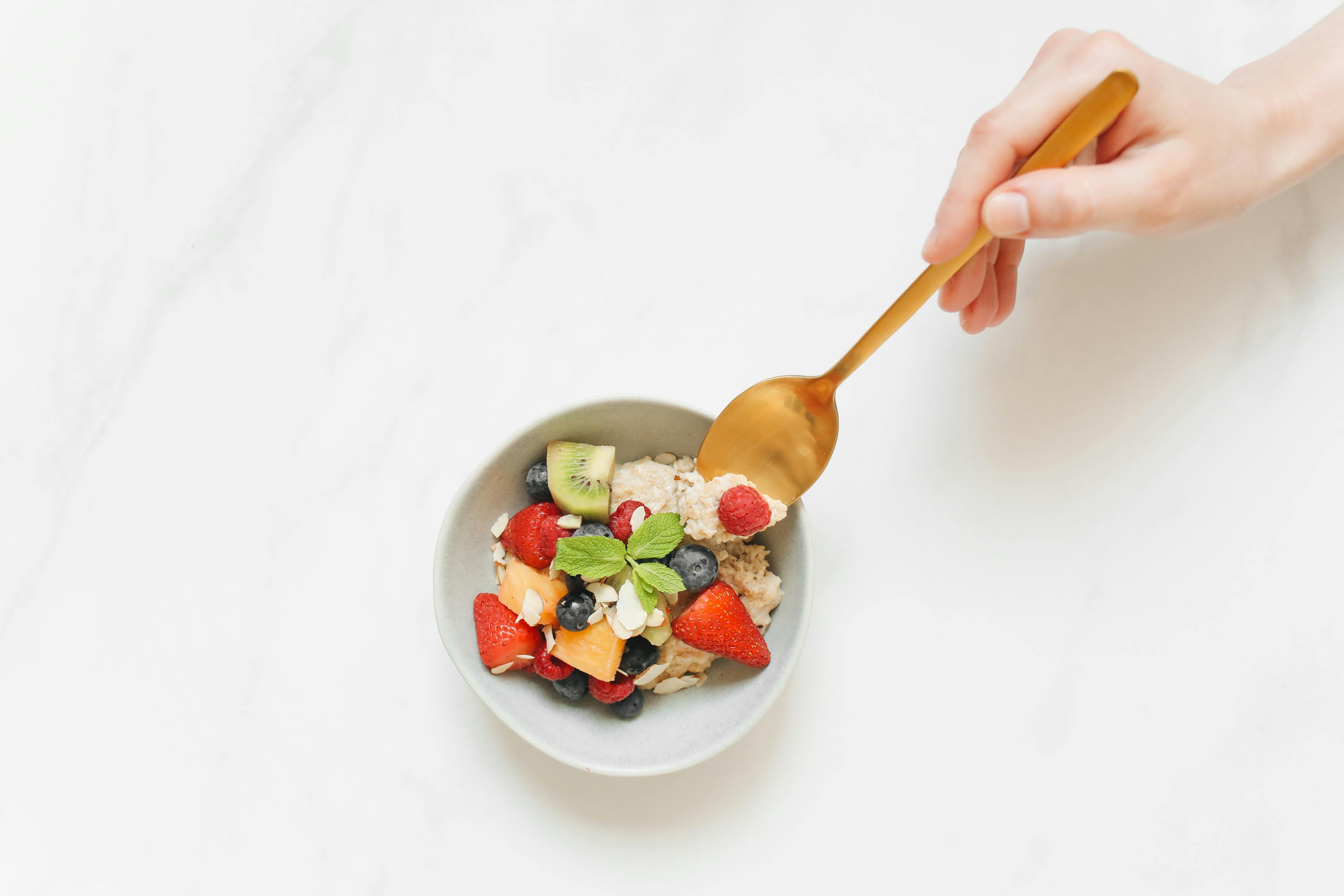 person holding a gold spoon scooping food