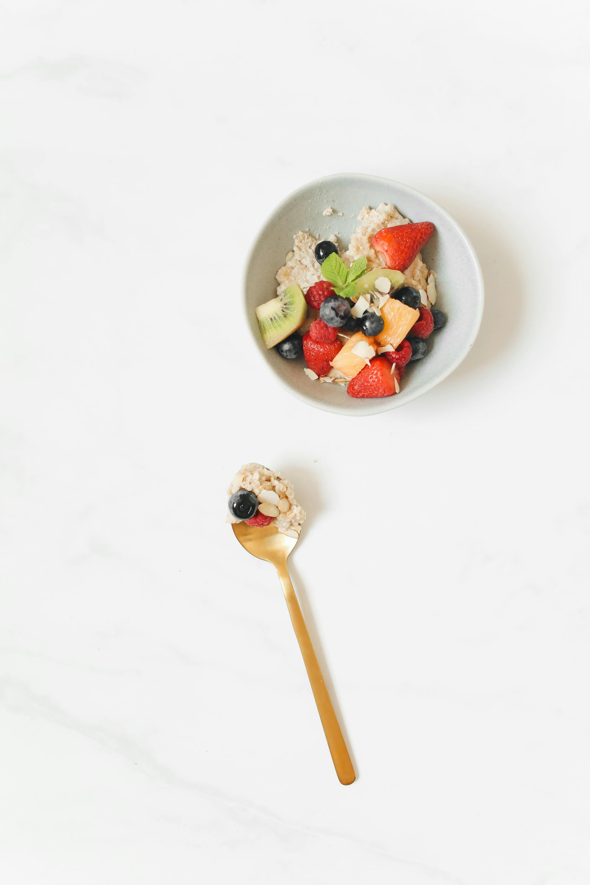 breakfast bowl beside a gold spoon with food