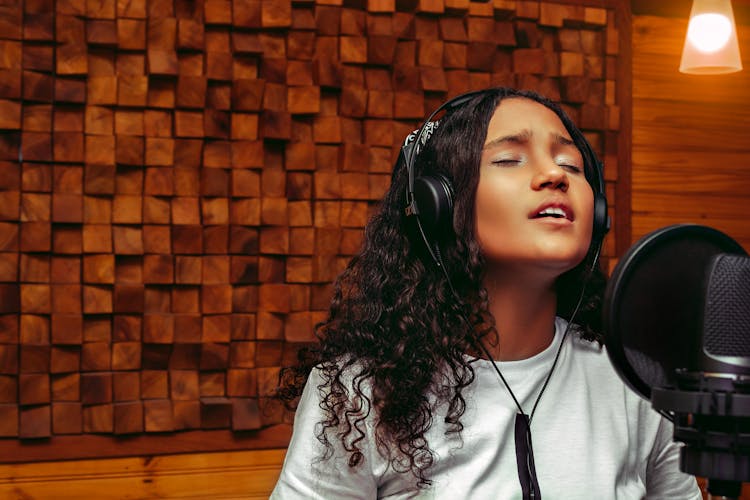 Girl In A White Shirt Wearing Headphones Singing