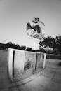 Young active man jumping across obstacle