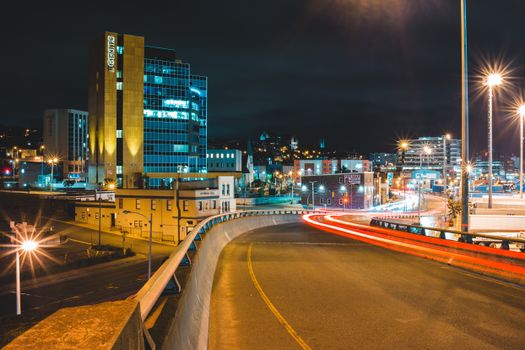 夜之城市中心，当代高层建筑附近的沥青道路交通明亮