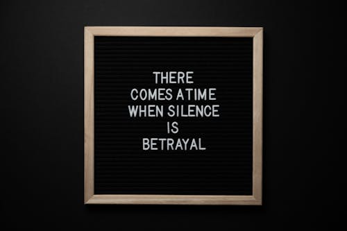 Free From above chalkboard with THERE COMES A TIME WHEN SILENCE IS BETRAYAL inscription on black background Stock Photo
