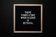 From above chalkboard with THERE COMES A TIME WHEN SILENCE IS BETRAYAL inscription on black background