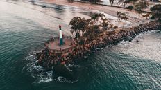 Drone view of modern lighthouse on tropical seashore