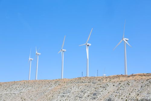 Free Vibrant blue cloudless sky over tall white wind turbines on slope in empty field in daytime Stock Photo
