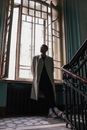 Man in White Coat Standing Near Window