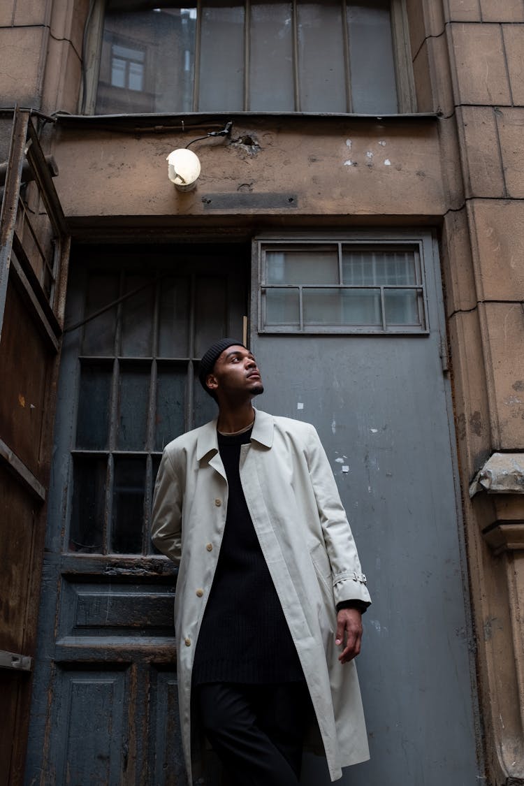 Man In White Button Up Shirt Standing Beside Brown Wooden Door