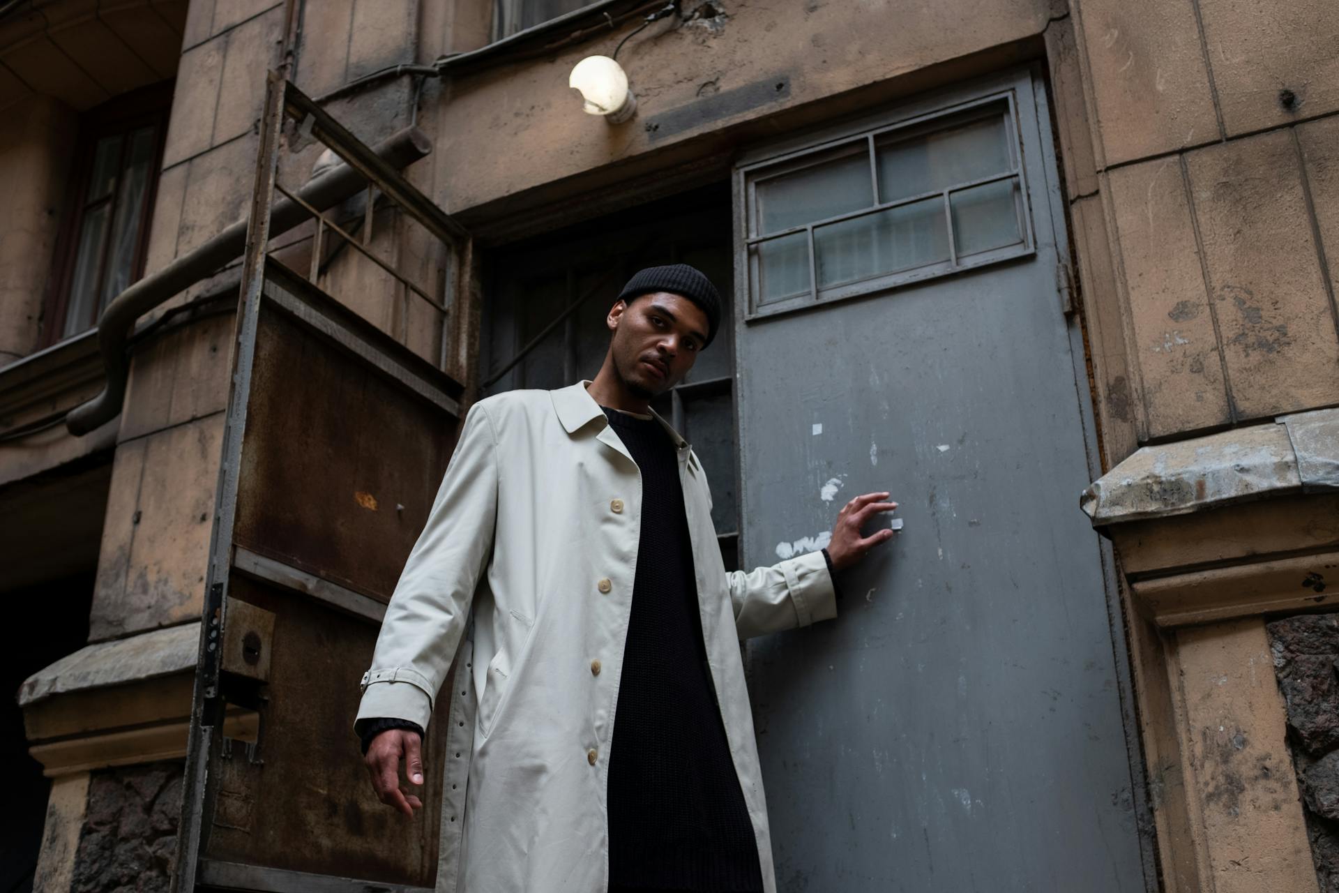 Man in White Coat Standing Beside Blue Wooden Door