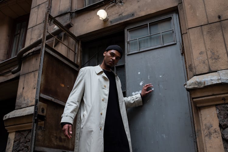 Man In White Coat Standing Beside Blue Wooden Door