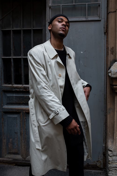 Man in White Coat Standing Beside Gray Wooden Door · Free Stock Photo