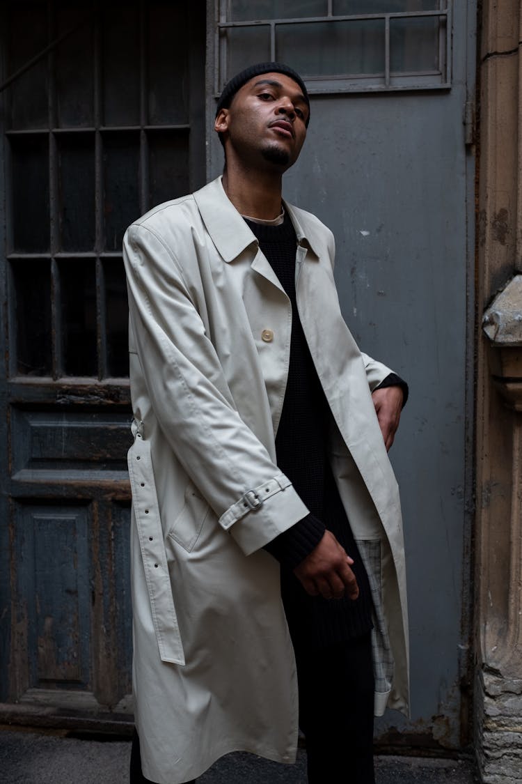 Man In White Coat Standing Beside Gray Wooden Door