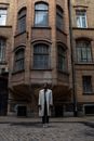 Man in White Thobe Standing Beside Brown Concrete Building