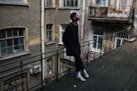 一名男子站在城区一栋复古建筑的破旧阳台上