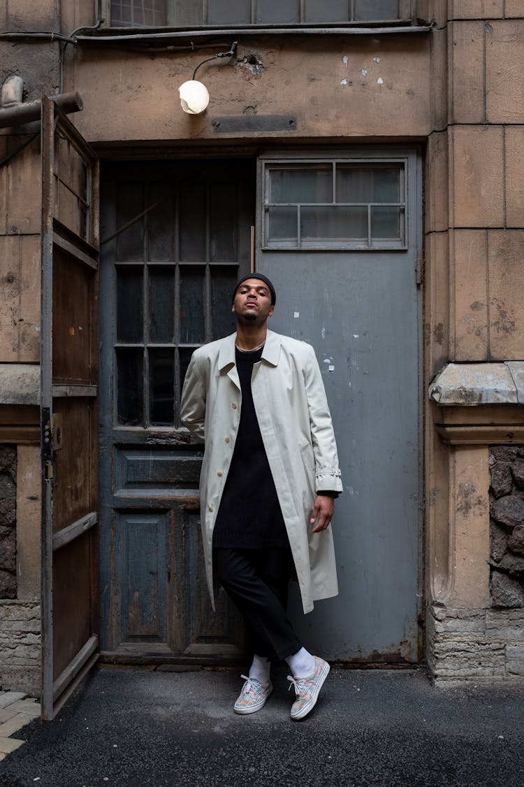 Man In White Coat Standing Beside Brown Wooden Door