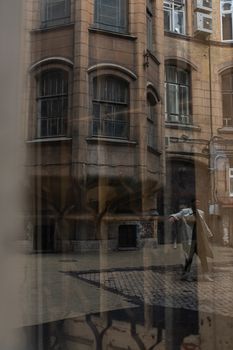鹅卵石街道上，一座古老建筑的倒影中，有一个跳舞的身影