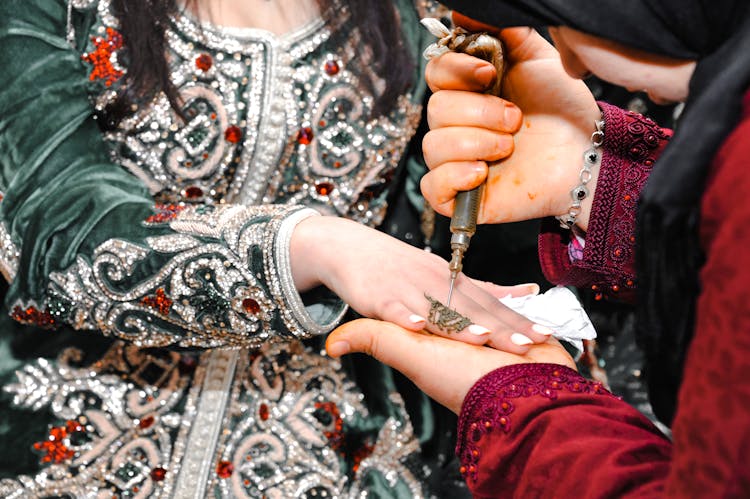 Woman Applying Henna Tattoo On Finger