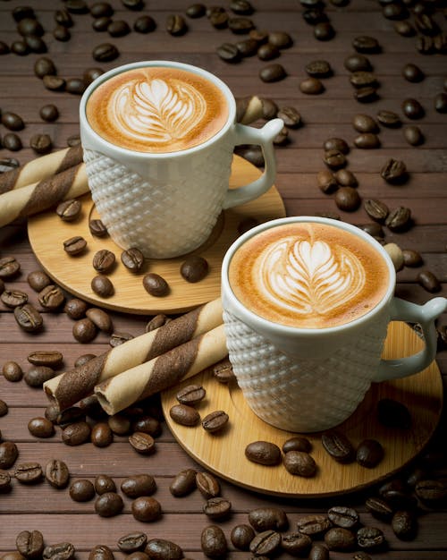 Free White Ceramic Cups With Coffee on Brown Wooden Coaster Stock Photo