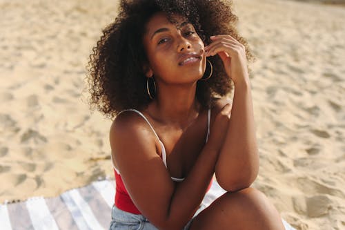 Woman in Red and White Spaghetti Strap Top Sitting on Sand