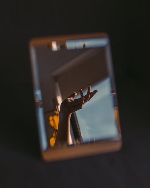 Foto profissional grátis de espelho, fundo preto, mão