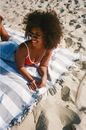 Smiling Woman Lying on Blanket on Beach